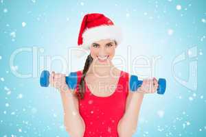 Composite image of festive fit brunette holding dumbbells