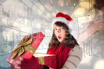 Composite image of young woman opening a glowing christmas gift