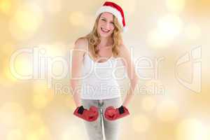 Composite image of festive blonde with boxing gloves posing