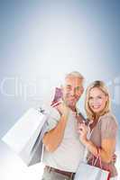 Composite image of happy couple with shopping bags and credit card