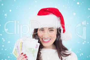 Composite image of happy brunette holding her cash
