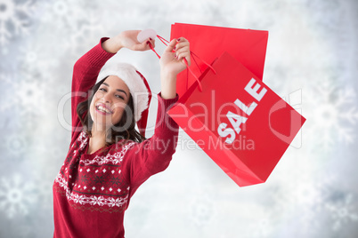 Composite image of pretty brunette showing sale bag and shopping