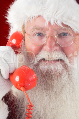 Composite image of santa on his red phone