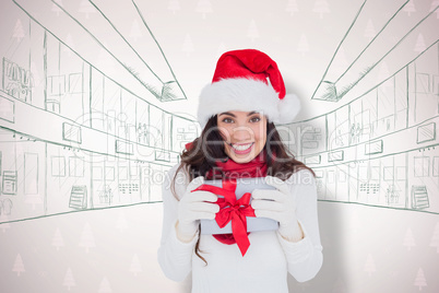 Composite image of festive brunette in santa hat holding gift