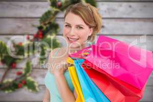 Composite image of portrait of cute young woman with shopping ba