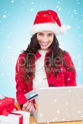 Composite image of festive brunette shopping online