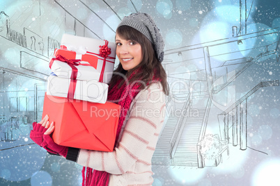 Composite image of festive brunette holding pile of gifts