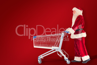 Composite image of santa pushes a shopping cart