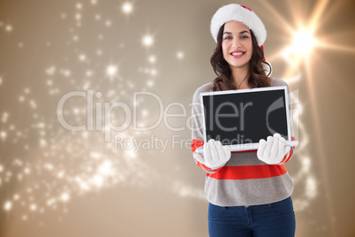 Composite image of festive brunette showing a laptop