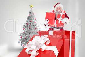 Composite image of santa standing in large gift