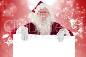 Composite image of santa is holding a sign