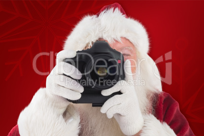 Composite image of santa is taking a picture