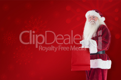 Composite image of santa carries red gift bag