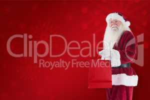 Composite image of santa carries red gift bag