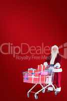 Composite image of santa pushes a shopping cart with presents