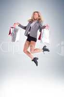 Stylish blonde jumping with shopping bags
