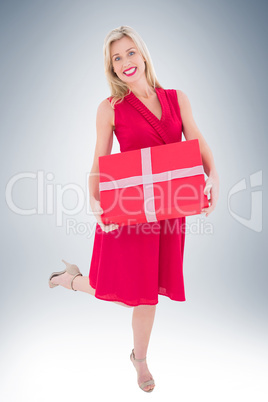 Stylish blonde in red dress holding gift