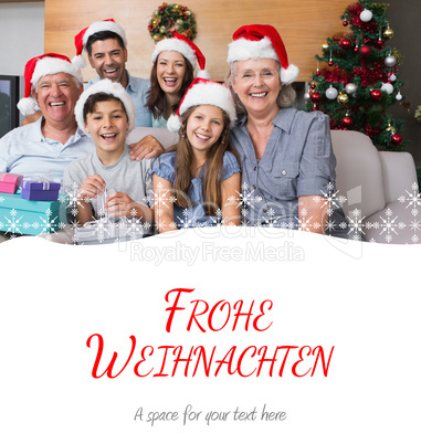 Composite image of extended family in christmas hats with gift b