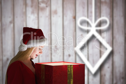 Composite image of festive blonde holding a gift