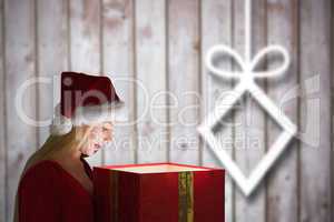 Composite image of festive blonde holding a gift