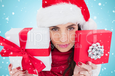 Composite image of pretty brunette showing christmas gifts