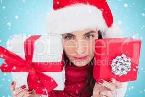 Composite image of pretty brunette showing christmas gifts