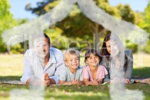 Composite image of family lying down in the park