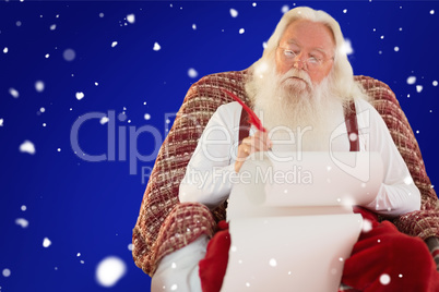 Composite image of father christmas writing list with a quill