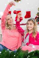 Composite image of festive mother and daughter smiling at camera