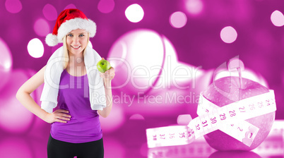 Composite image of festive fit blonde smiling at camera holding