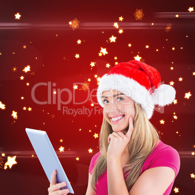 Composite image of festive blonde using tablet pc