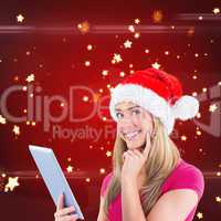 Composite image of festive blonde using tablet pc