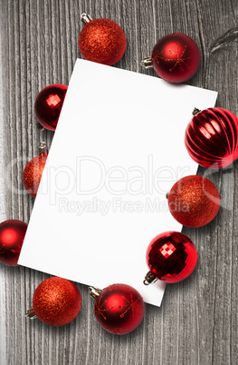 Composite image of red christmas baubles surrounding white page