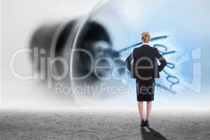 Composite image of businesswoman standing with hands on hips