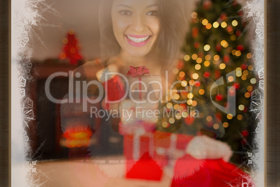 Composite image of pretty girl in santa outfit holding gift