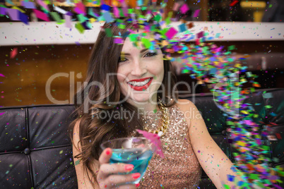 Composite image of pretty brunette drinking a cocktail
