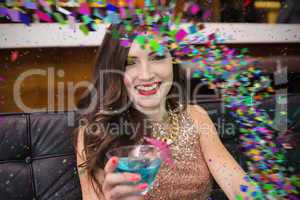 Composite image of pretty brunette drinking a cocktail