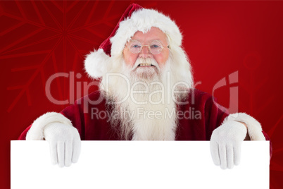 Composite image of santa looks over a sign