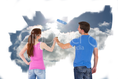 Composite image of couple painting a wall together