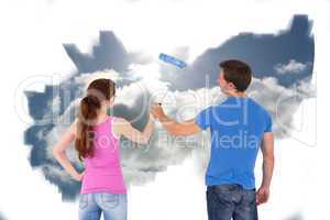 Composite image of couple painting a wall together