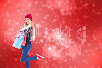 Composite image of festive blonde holding shopping bags