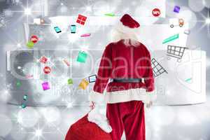 Composite image of santa carrying sack of gifts