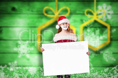 Composite image of festive redhead in foam beard holding poster