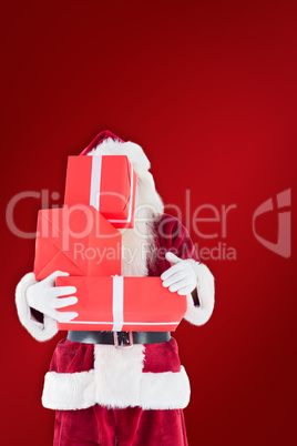 Composite image of santa covers his face with presents