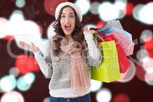 Composite image of excited brunette with shopping bags
