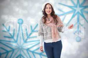 Composite image of brunette in winter clothes holding