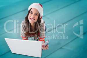 Composite image of happy brunette shopping online with laptop