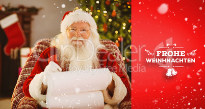 Composite image of happy santa writing list with a quill