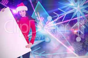 Composite image of smiling brunette in santa hat showing white p