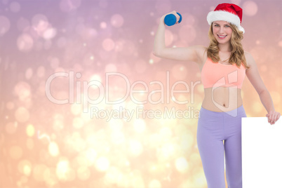 Composite image of festive fit blonde smiling at camera holding